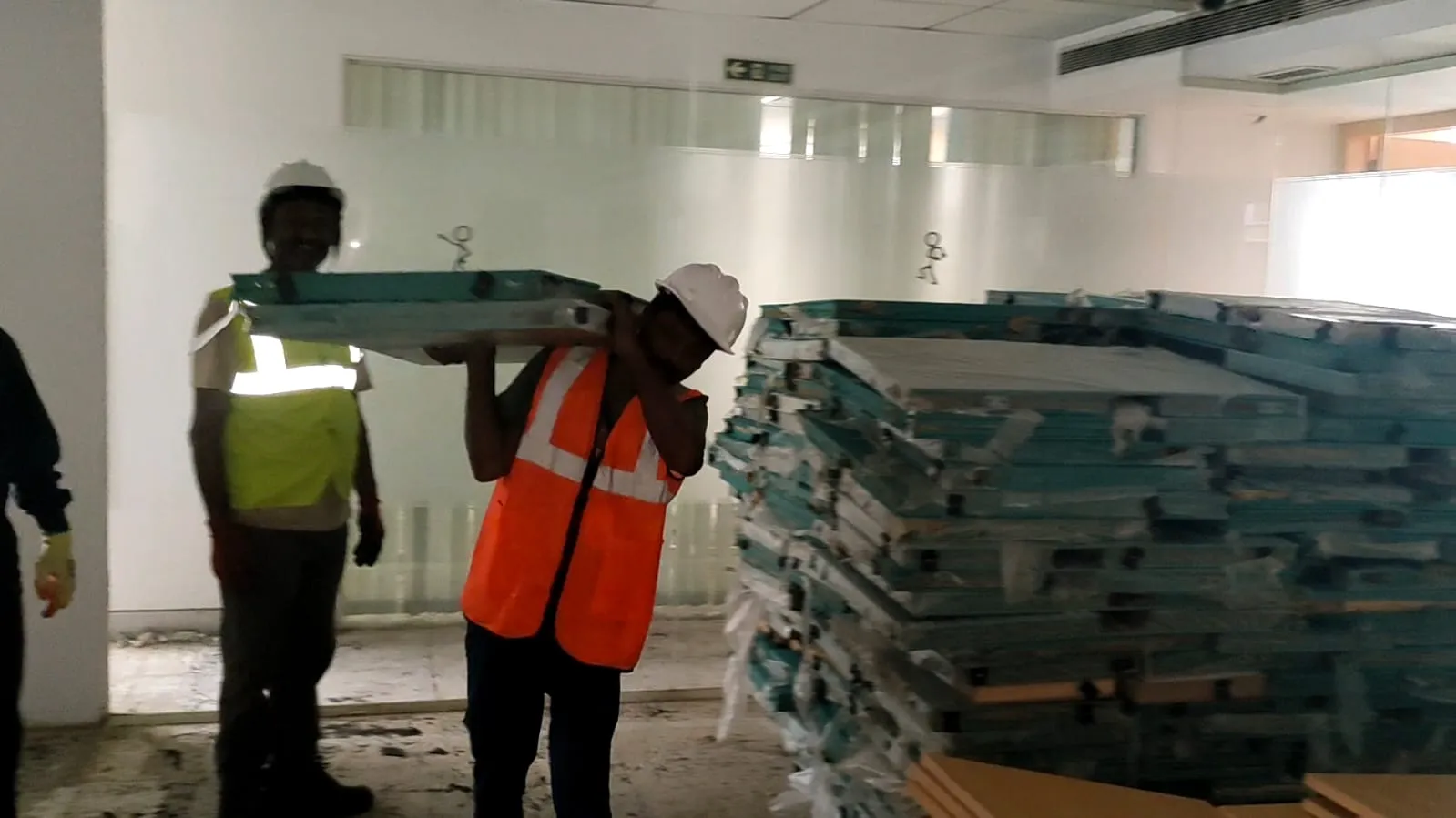 Disassembled corporate workspace desks stored flat-packed during an office furniture dismantling OMR project run.